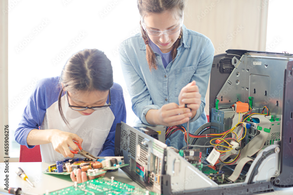 Girl students assembling computer in classroom Girl students assembling computer in classroom