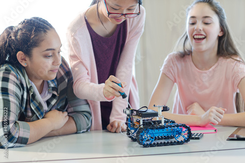 Students playing with robot in classroom