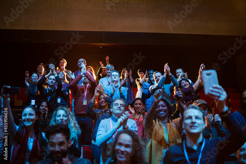 Excited audience with smart phone flashlights cheering