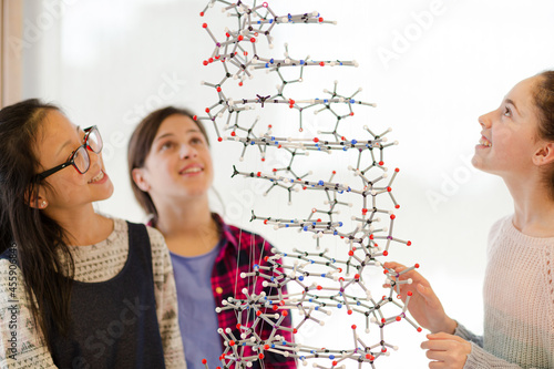 Fototapeta Naklejka Na Ścianę i Meble -  Curious girl students examining molecular structure in classroom