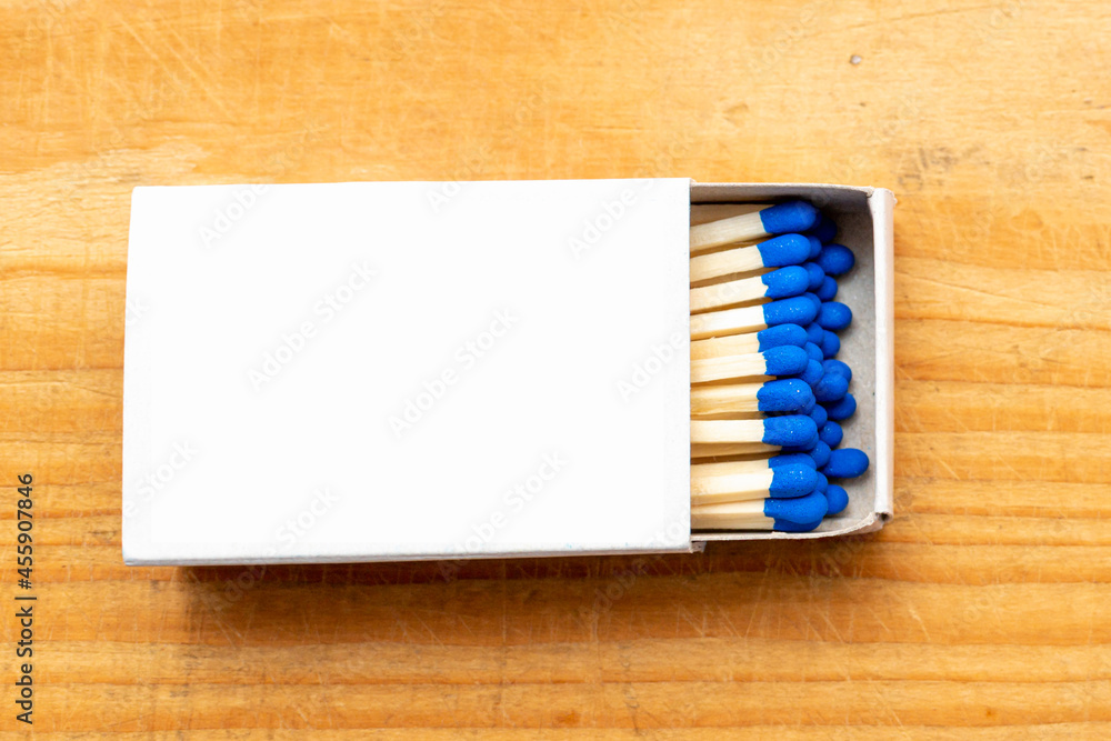 Obraz premium Cardboard box with matchsticks on wooden background, blank space top view. Space for design,flat lay copy space.Selective focus.