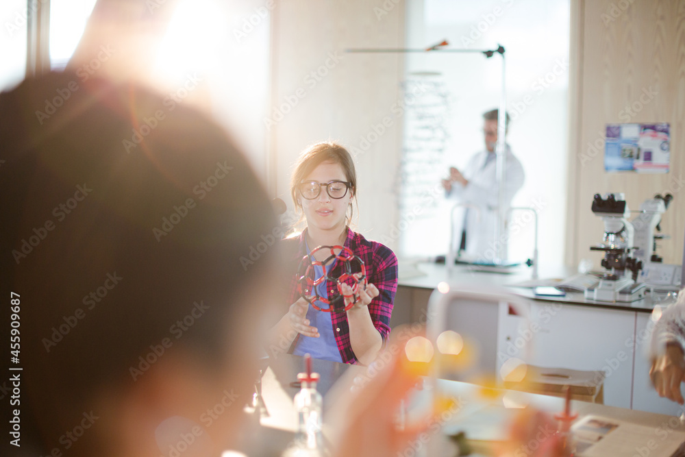Curious girl student examining molecular structure in classroom Curious girl student examining molecular structure in classroom