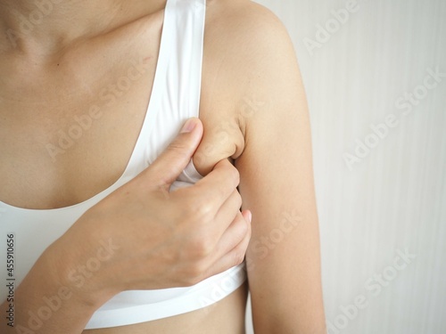 Asian woman pulling her skin underarm. problem armpit fat skin concept. closeup photo, blurred. photo