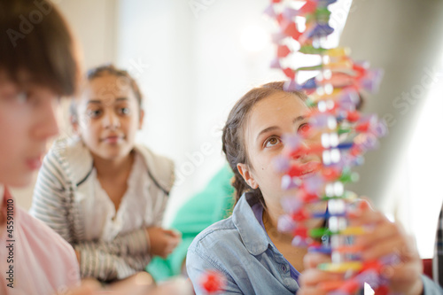 Students examining DNA model in classroom laboratory