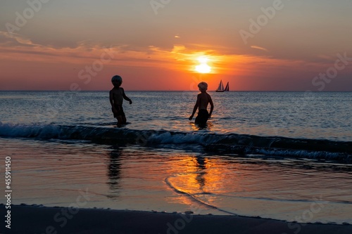 Happy Children Playing On The Beach During Sunset Time Summer Vacation And Healthy Lifestyle Concept. © AVC Photo Studio