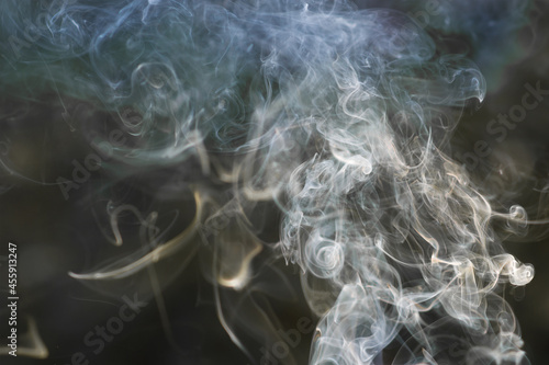 The beautiful smoke dissipates into the air. A lot of smoke at sunset on the street. Horizontal format. Place for text
