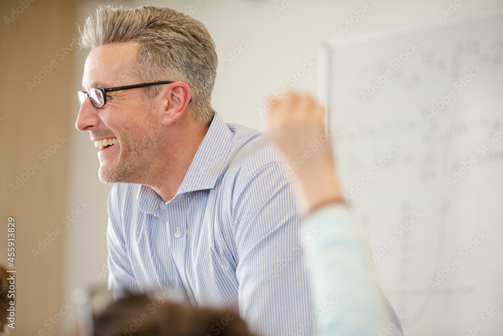 Fototapeta premium Male teacher leading lesson at whiteboard in classroom