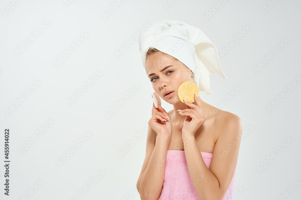 woman with bare shoulders with a towel on her head cleaning facial skin woman with bare shoulders with a towel on her head cleaning facial skin