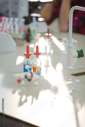 Liquid in bottles, test tubes and beakers in science laboratory classroom