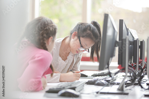 Girl students working at computer in library