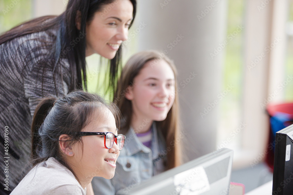 Female teacher and girl students using computer Female teacher and girl students using computer