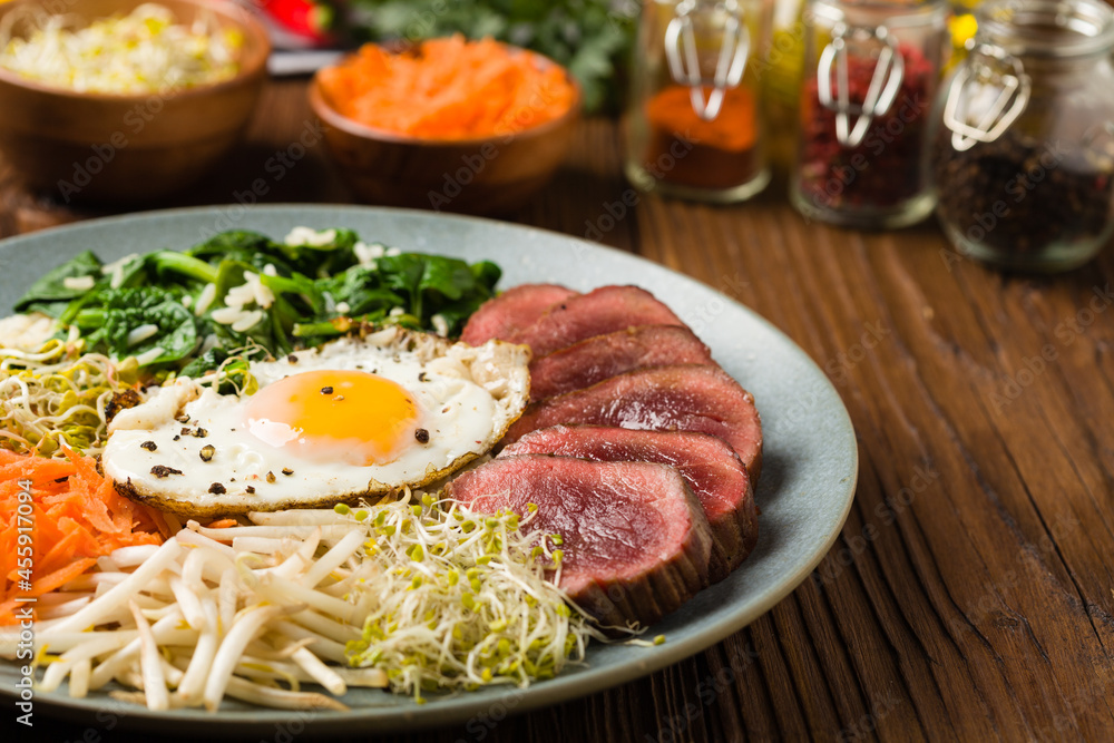 Korean beef with sprouts, spinach and fried egg.