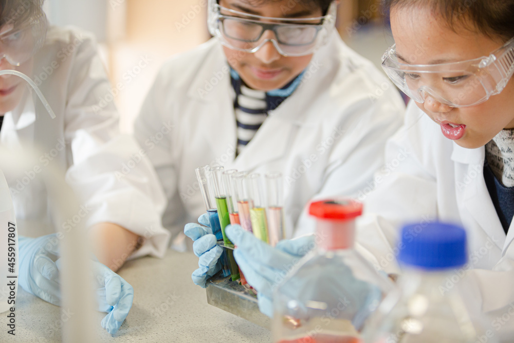 Students conducting scientific experiment in laboratory classroom Students conducting scientific experiment in laboratory classroom