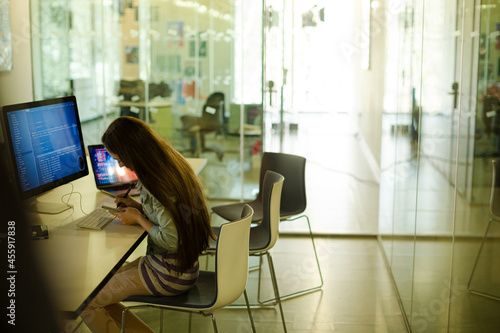 Girl student using computer at desk photo