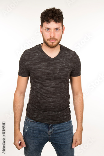 portrait isolated caucasian young man with serious expression with arms down