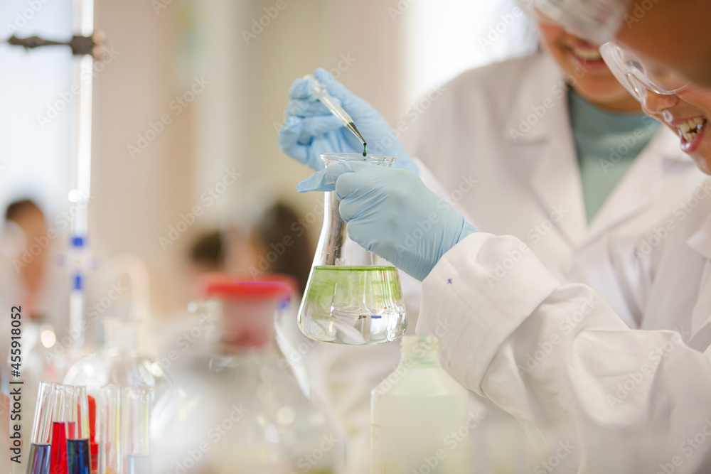 Students conducting scientific experiment in laboratory classroom Students conducting scientific experiment in laboratory classroom