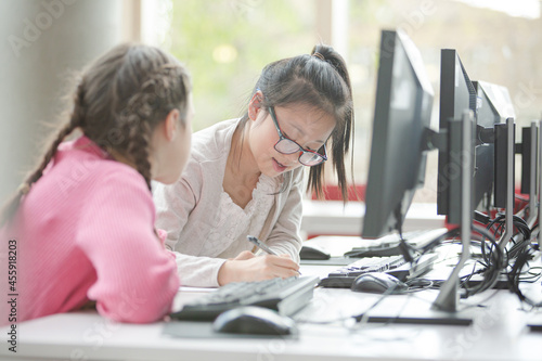 Girl students working at computer in library