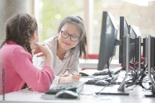 Girl students working at computer in library