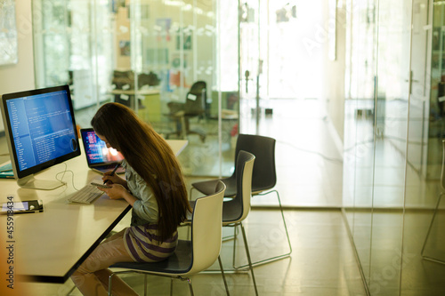 Girl student using computer at desk photo