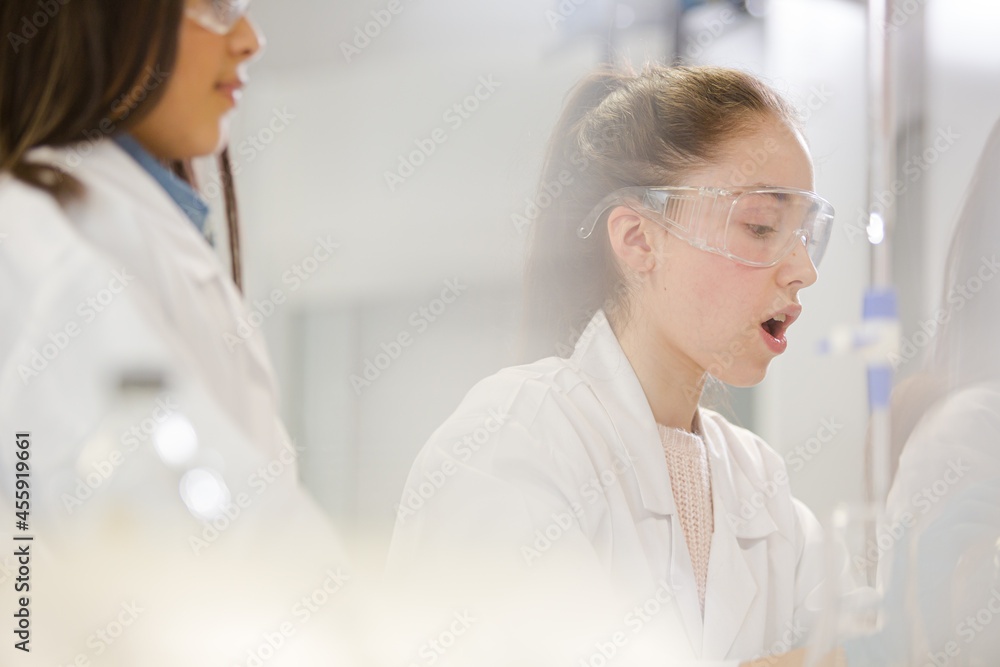 Girl students conducting science experiment in classroom laboratory Girl students conducting science experiment in classroom laboratory