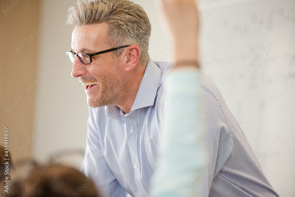 Male teacher leading lesson at whiteboard in classroom Male teacher leading lesson at whiteboard in classroom