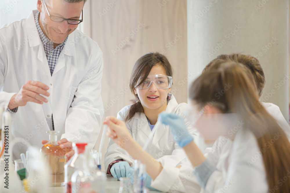 Male teacher and student conducting scientific experiment in laboratory classroom Male teacher and student conducting scientific experiment in laboratory classroom