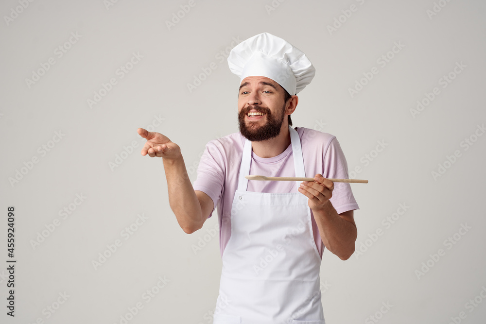professional chef in uniform with a spoon in his hands work light background professional chef in uniform with a spoon in his hands work light background