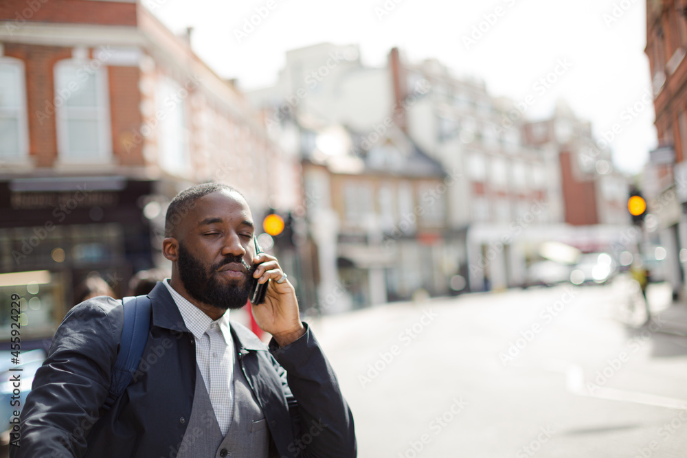 Young businessman talking on cell phone and hailing taxi on sunny urban street Young businessman talking on cell phone and hailing taxi on sunny urban street