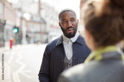 Smiling businessman with bicycle and woman on urban street