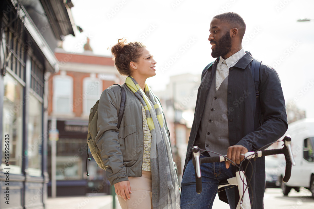 Smiling businessman with bicycle and woman on urban street Smiling businessman with bicycle and woman on urban street