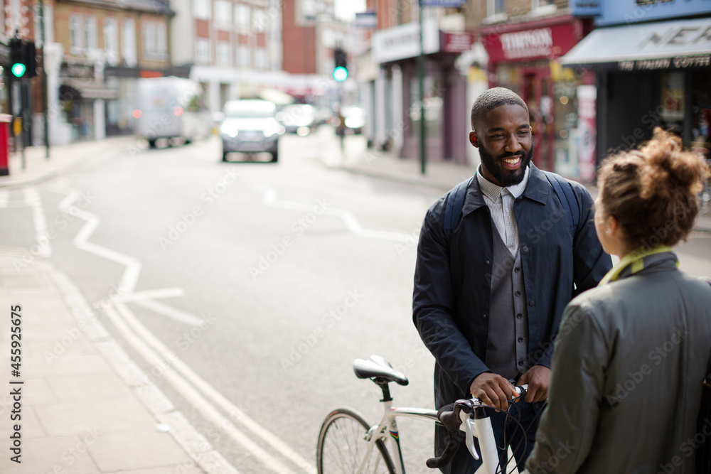 Smiling businessman with bicycle and woman on urban street Smiling businessman with bicycle and woman on urban street