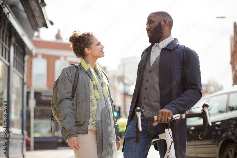 Smiling businessman with bicycle and woman on urban street Smiling businessman with bicycle and woman on urban street