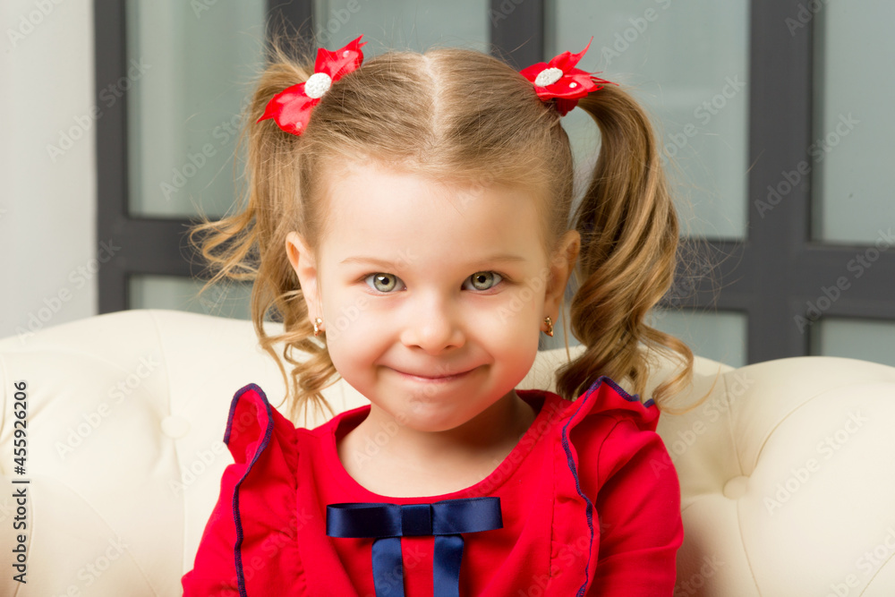 Cute blonde little girl sitting on comfy armchair Cute blonde little girl sitting on comfy armchair