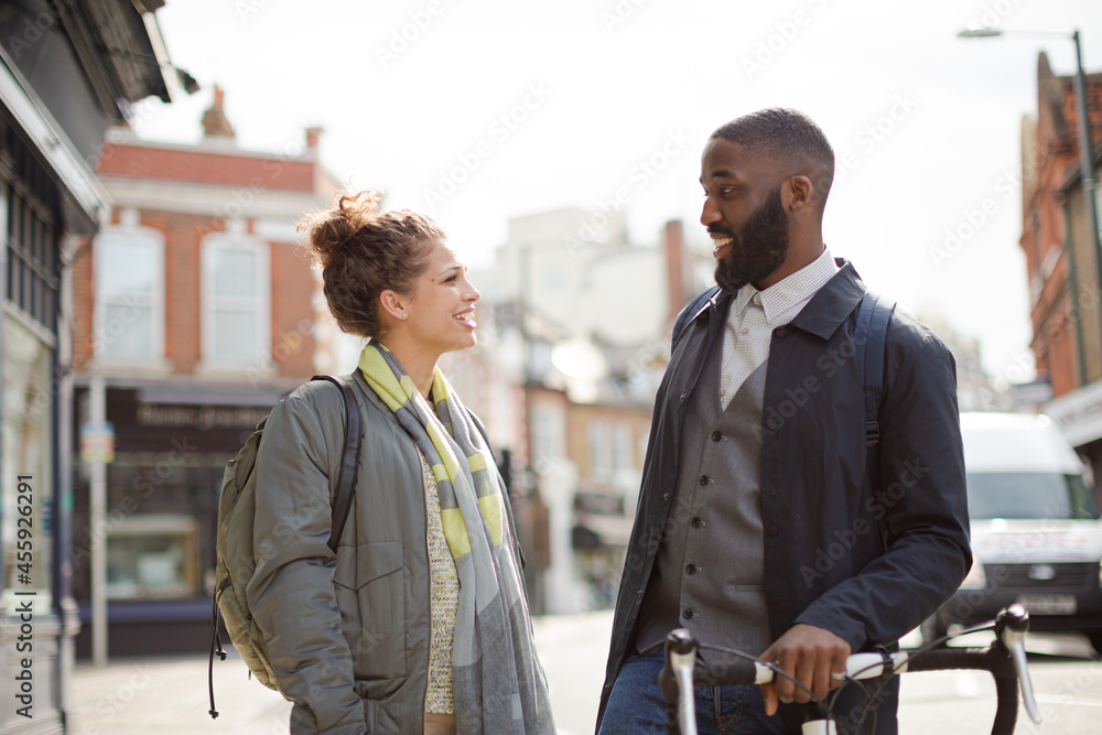 Smiling businessman with bicycle and woman on urban street Smiling businessman with bicycle and woman on urban street