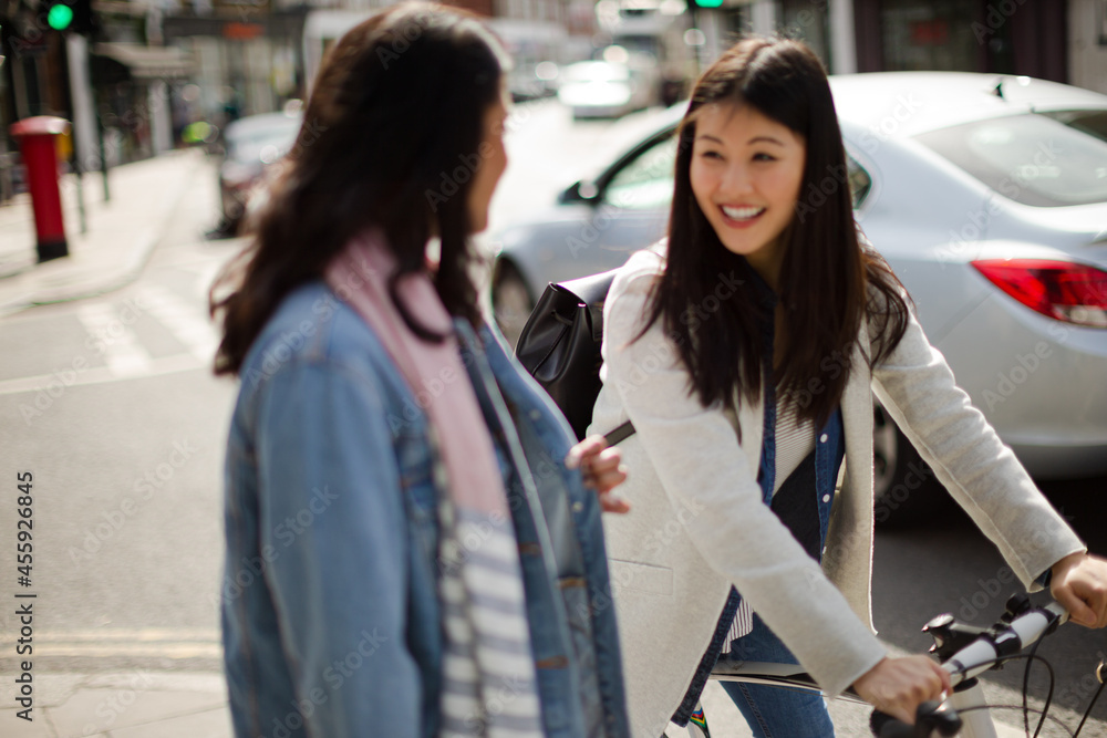 Smiling women friends talking on urban street Smiling women friends talking on urban street