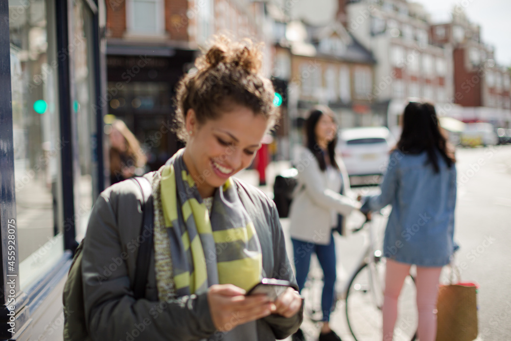 Young woman texting on sunny urban street Young woman texting on sunny urban street