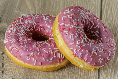 Tasty glazed raspberry donut with topping.