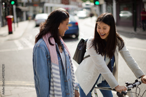 Smiling women friends talking on urban street