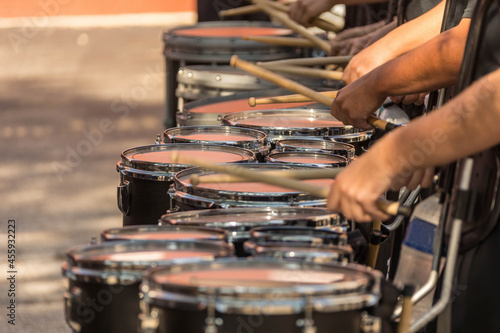 section of a marching band drum line warming up for a parade