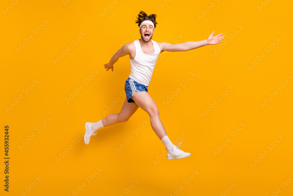 Full length body size view of attractive cheerful crazy guy jumping running having fun isolated over bright yellow color background
