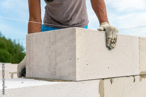 Builder makes a concrete wall with cement blocks on the construction site of a house. Concept of building a house