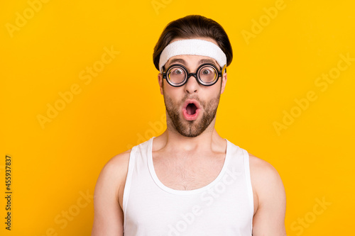 Portrait of attractive amazed worried guy nerd sportsman opened mouth stupor isolated over bright yellow color background © deagreez