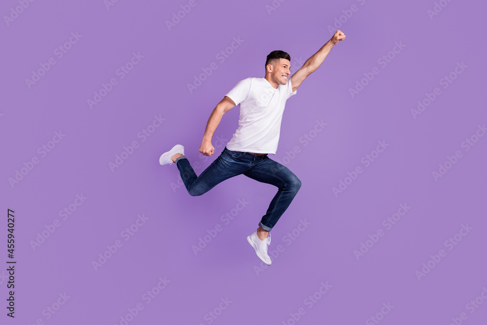 Full length profile side photo of young man happy positive smile jump fly air superman isolated over violet color background
