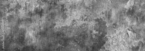 Dark grey rough concrete wall with cracked elements