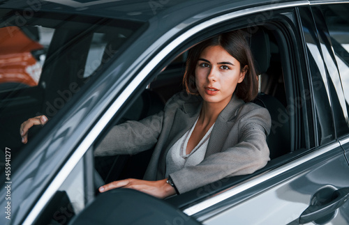 Woman testing new car. Sitting indoors in modern automobile © standret