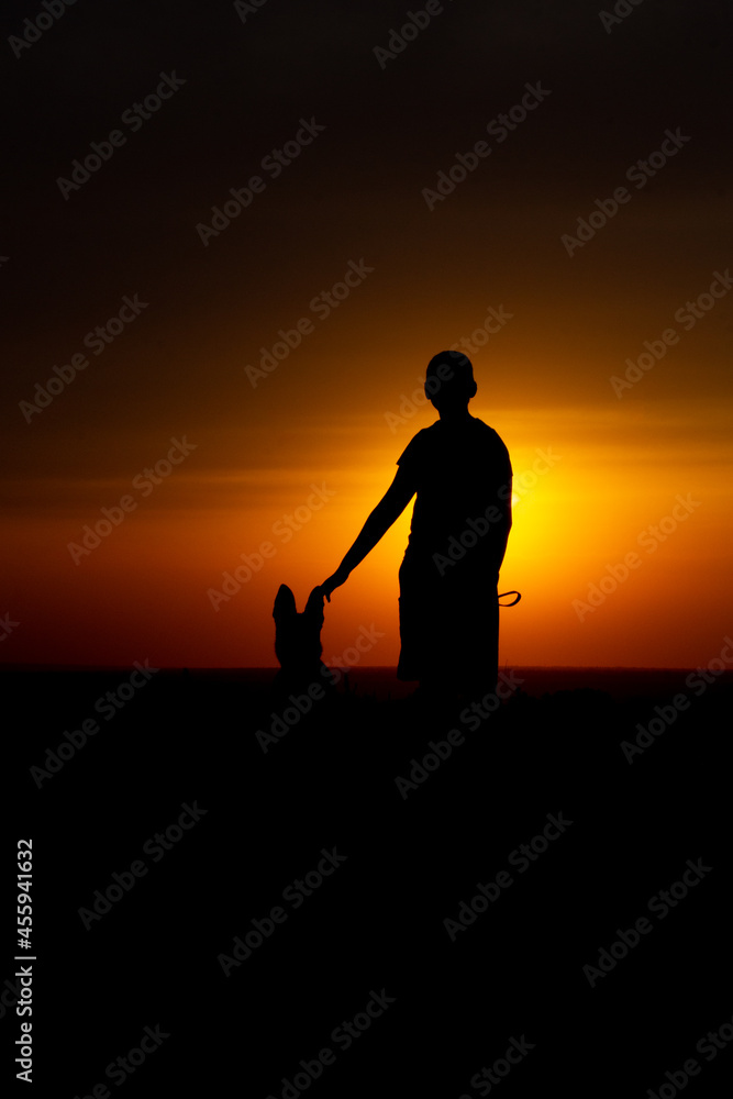 man with dog at sunset