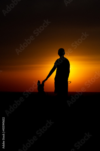 man with dog at sunset