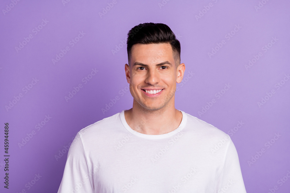 Fototapeta premium Photo of charming young happy man smile good mood wear white t-shirt isolated on purple color background