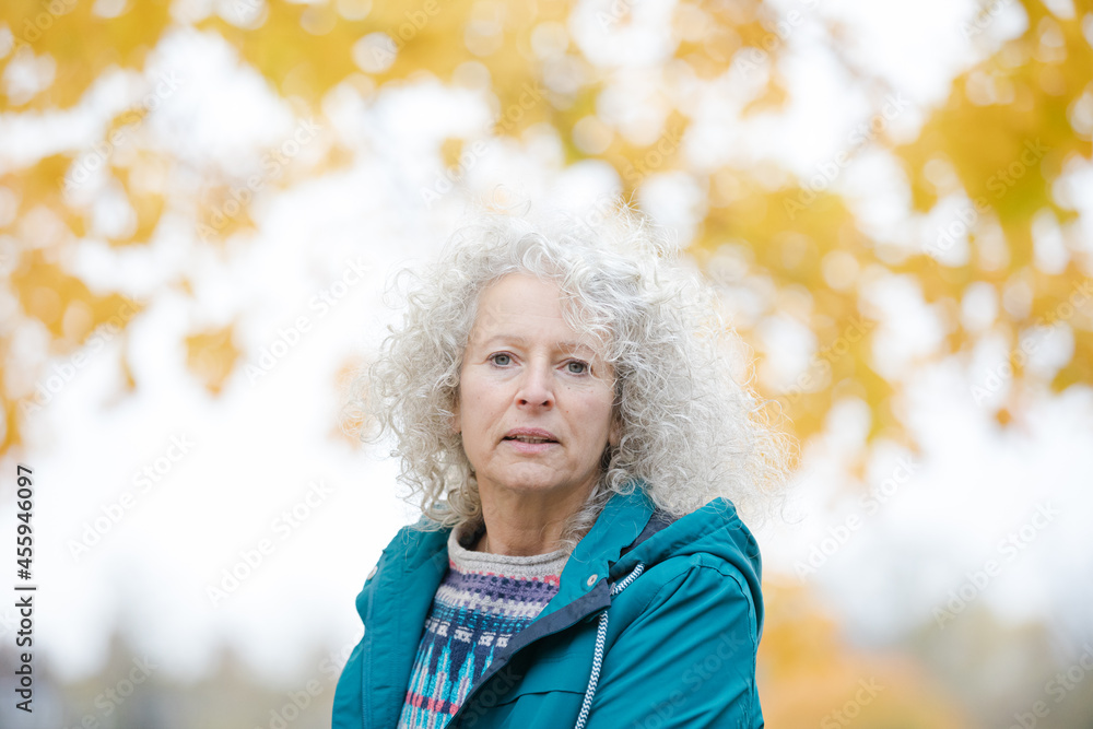 Portrait smiling woman among leaves and trees in autumn park Portrait smiling woman among leaves and trees in autumn park
