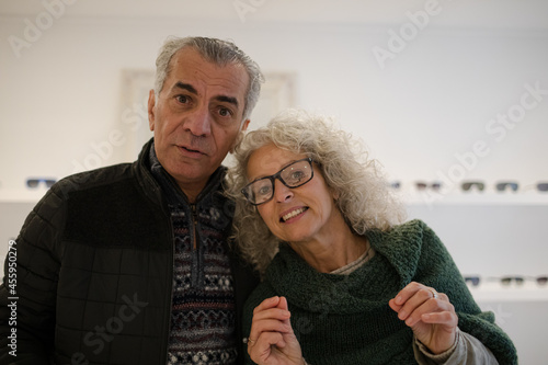 Senior couple shopping for eyeglasses in optometry shop